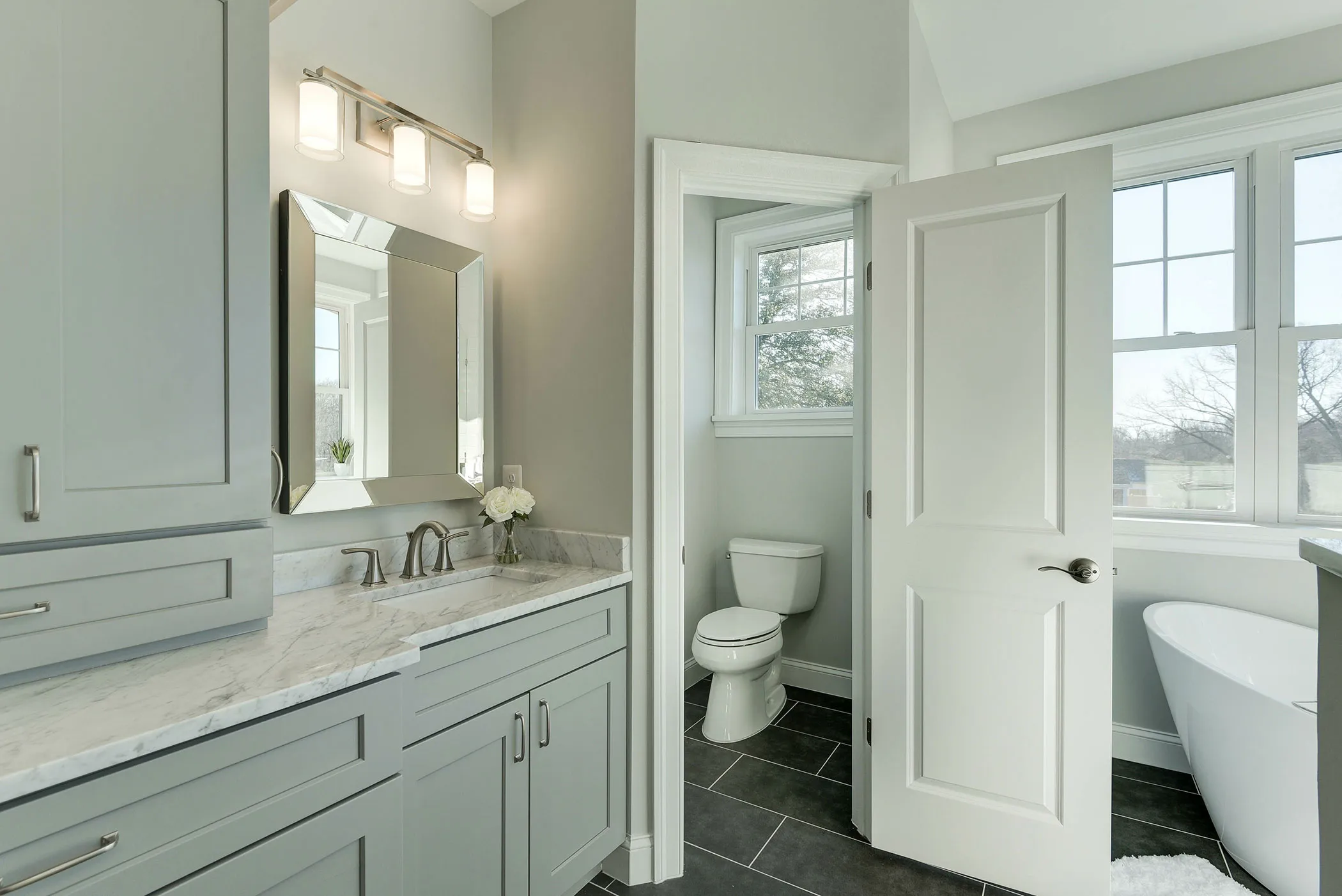 a bathroom with a white bath, toilet and sink